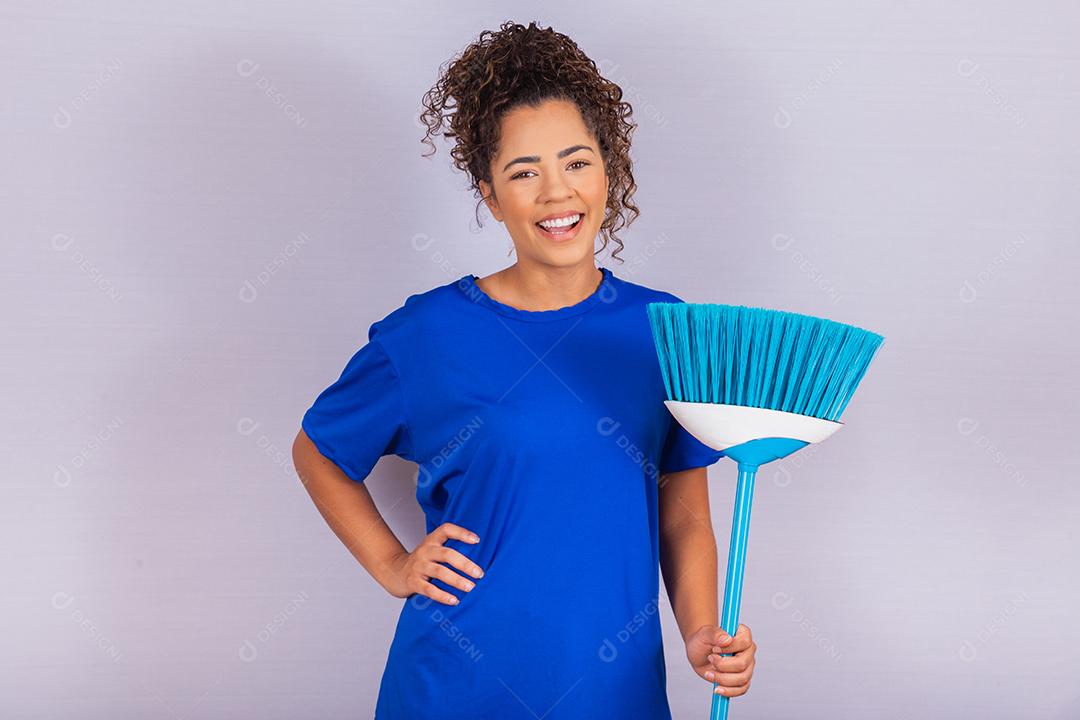 Mulher dona de casa. Limpador. Jovem segurando a vassoura em fundo branco