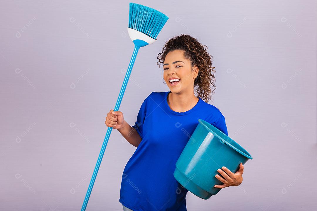 Jovem mulher segurando ferramentas de limpeza isoladas em branco. Mulher dona de casa. Limpador.