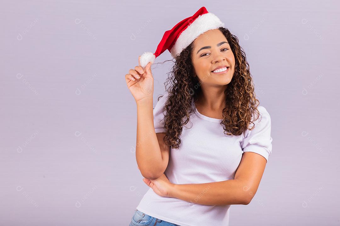 beautiful and cheerful girl in Santa Claus hat smiling at camera