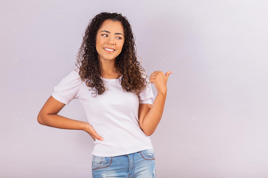 Jovem mulher com laço vermelho na camiseta para campanha de prevenção do HIV. Apontando