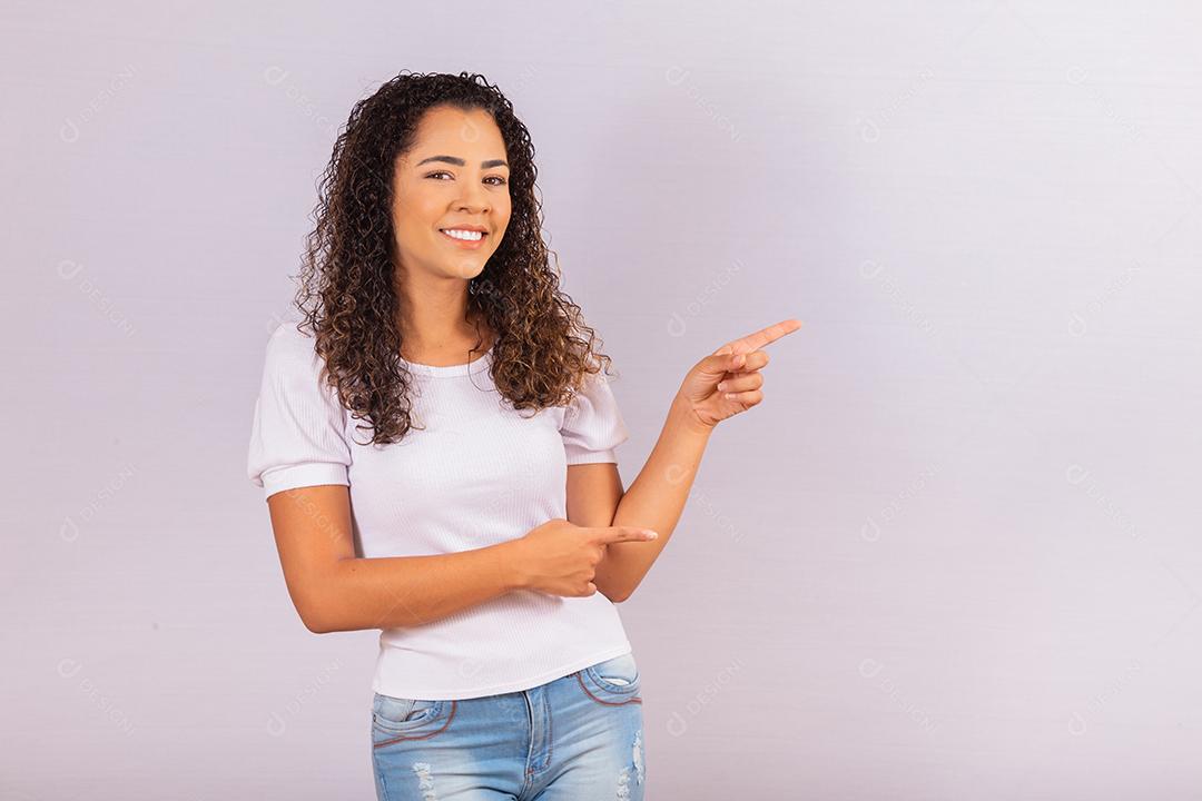 Imagem de alegre jovem afro apontando