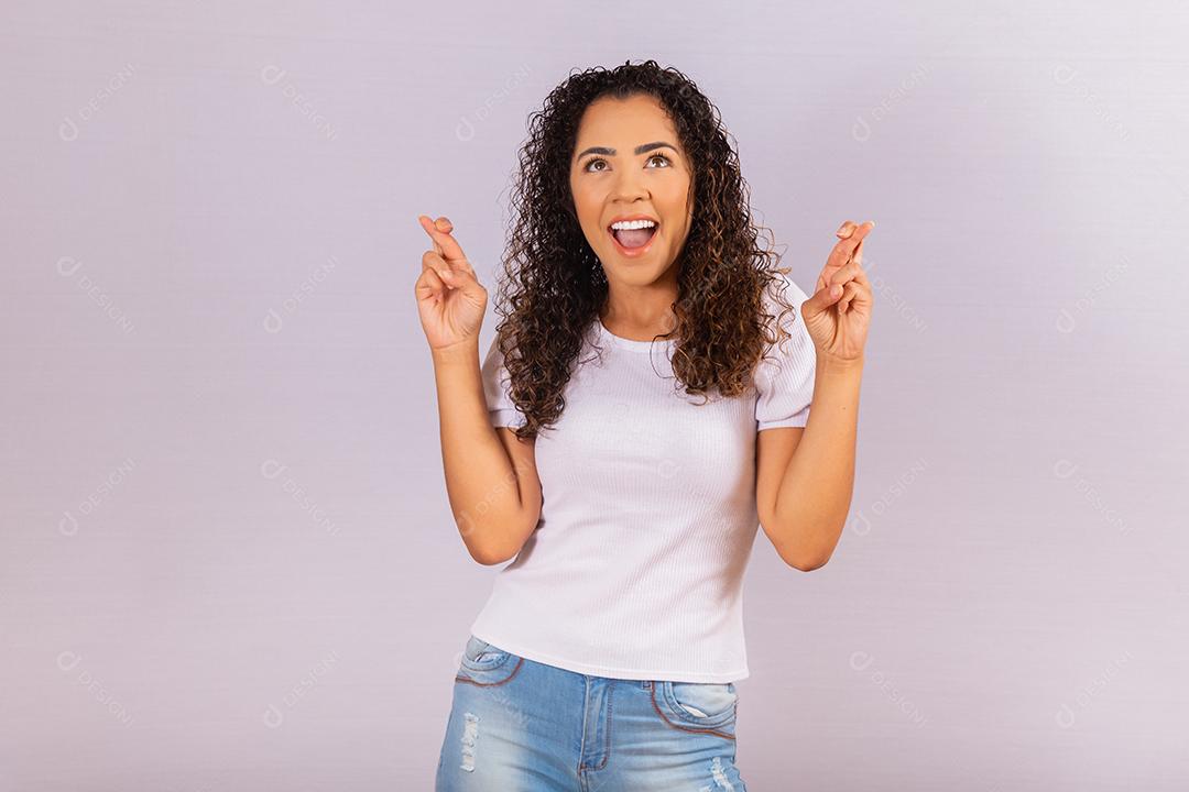 jovem afro com dedos cruzados. Sorte