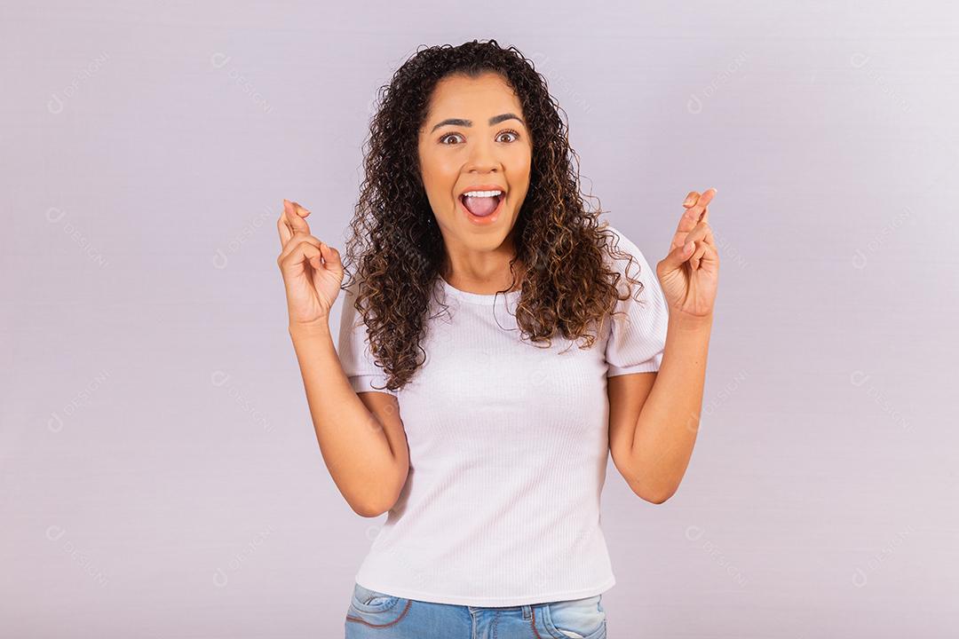 jovem afro com dedos cruzados. Sorte