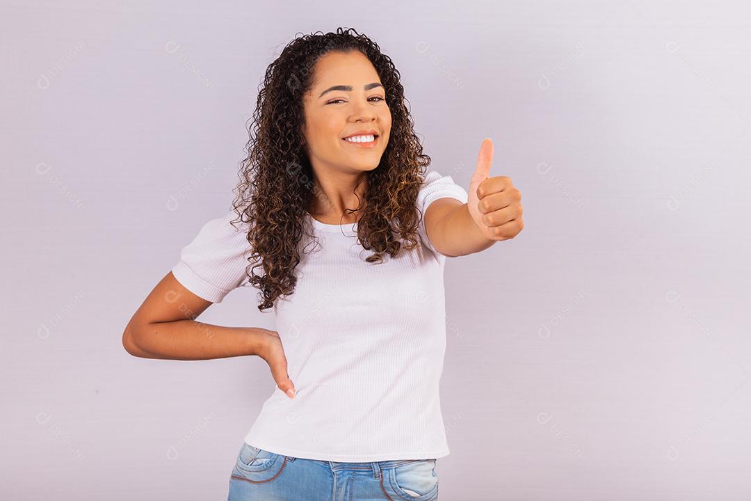 Retrato de sorrir bela jovem afro polegares para cima. menina brasileira.