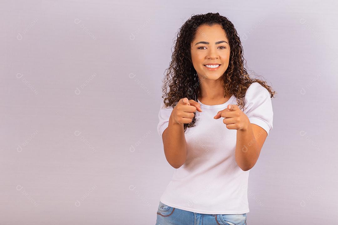 Mulher afro olhando a câmera enquanto aponta para você