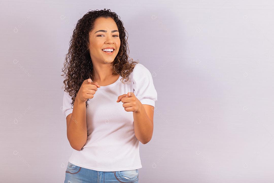 Mulher afro olhando a câmera enquanto aponta para você