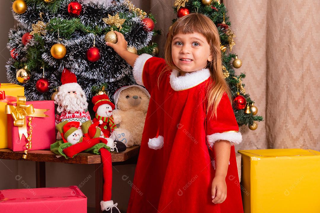 Garoto caucasiano organiza decorar a árvore de natal com o conceito de ideias festivas de natal divertidas e alegres