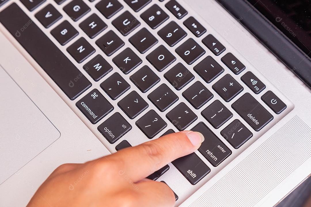 Dedo empurrando o botão enter do teclado