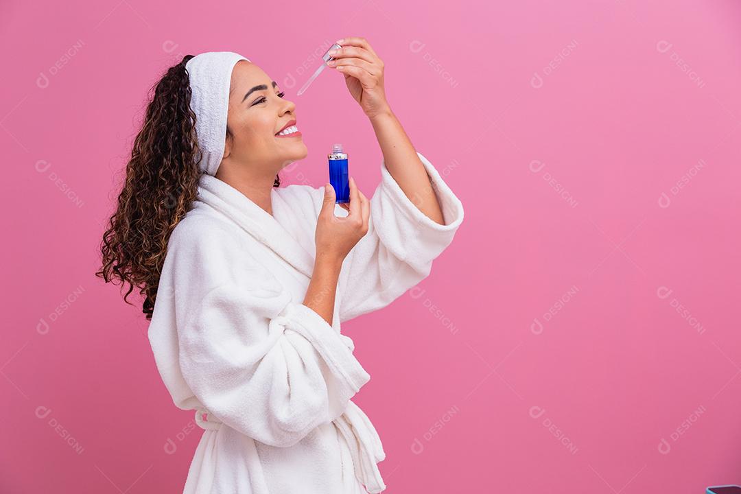 Linda jovem afro com óleo cosmético na cor de fundo