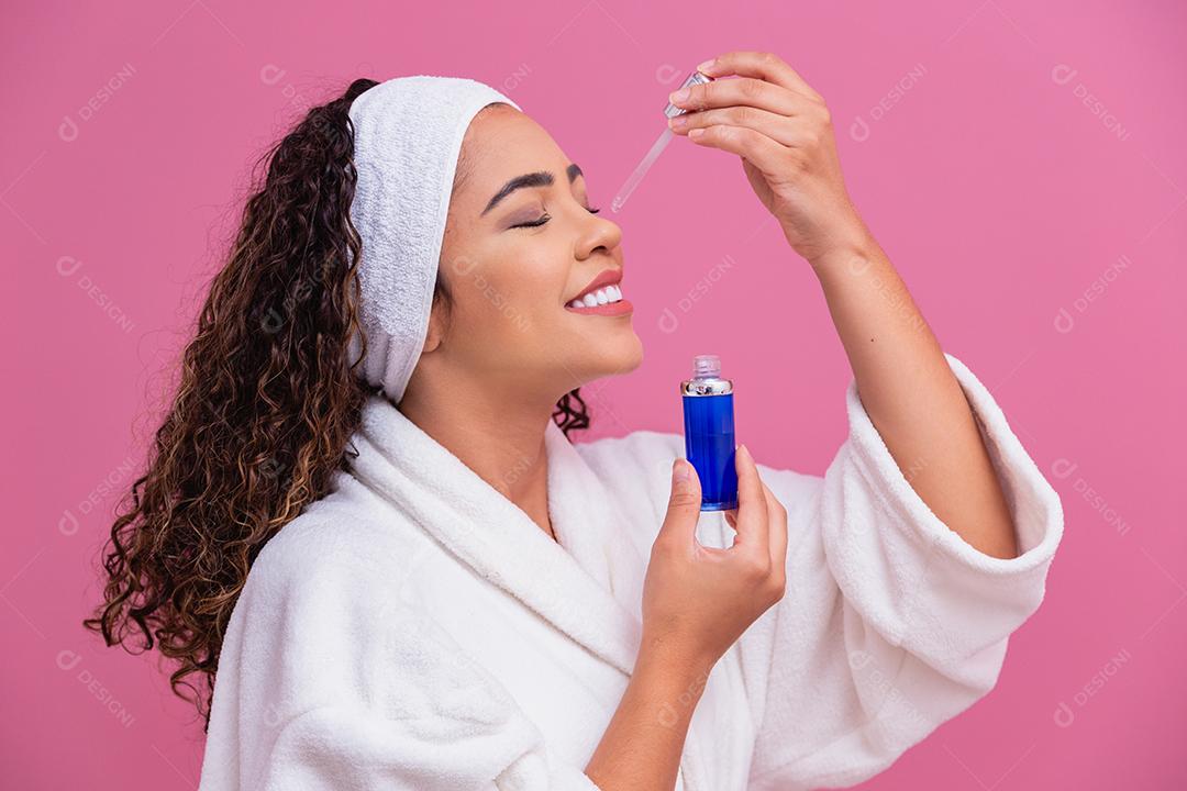 Linda jovem afro com óleo cosmético na cor de fundo