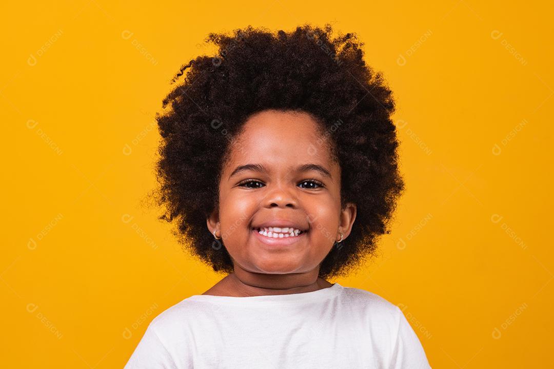 Menina negra feliz sorrindo sobre um fundo isolado amarelo