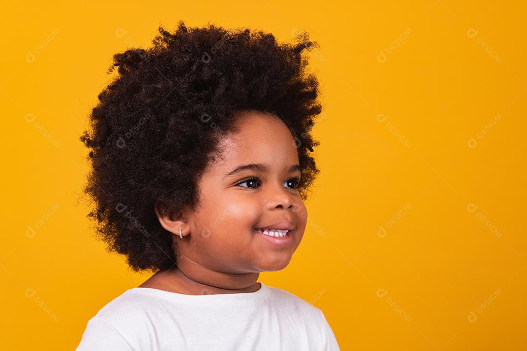 Menina negra feliz sorrindo sobre um fundo isolado amarelo