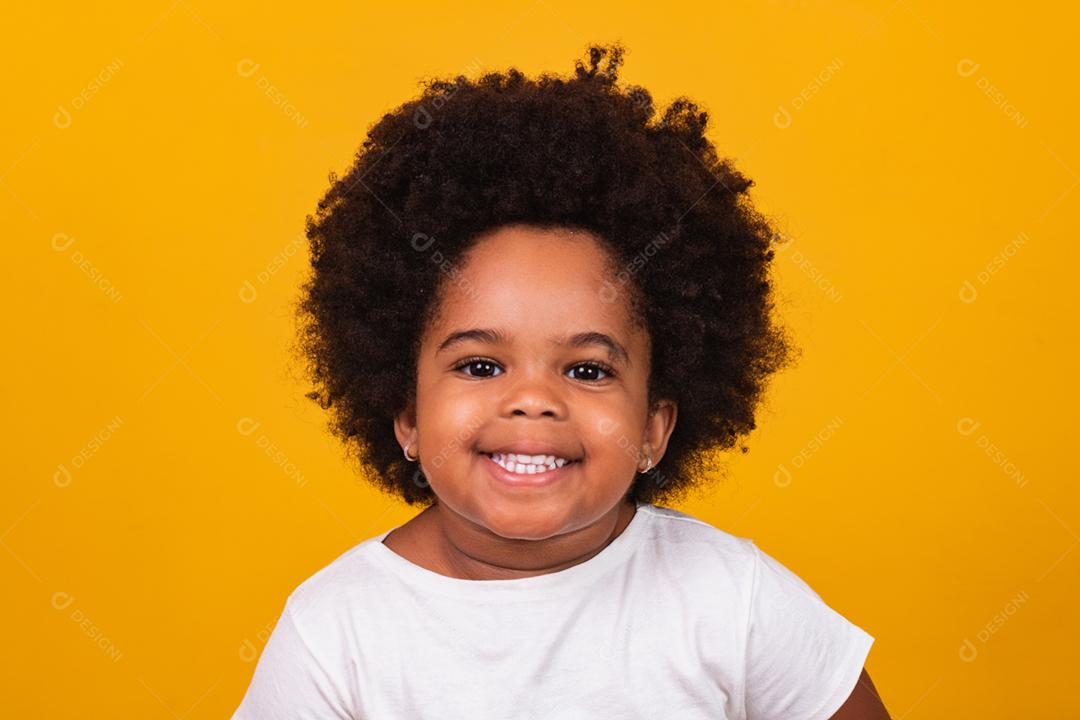 Linda garota afro com cabelo preto sorrindo para a câmera.