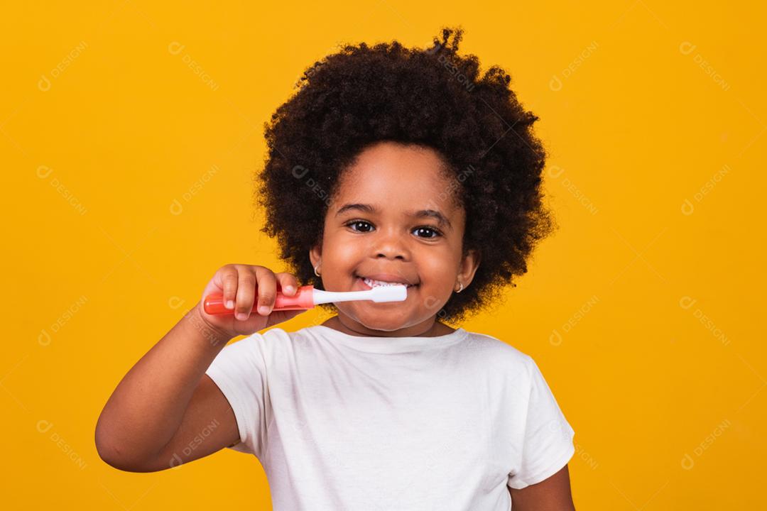 Uma garotinha afro-americana bonitinha escovando os dentes, isolada