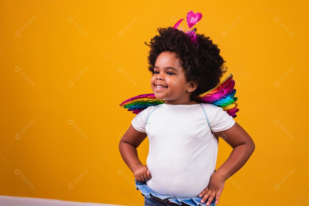 adorável garota afro vestida com roupa colorida em backgrou amarelo