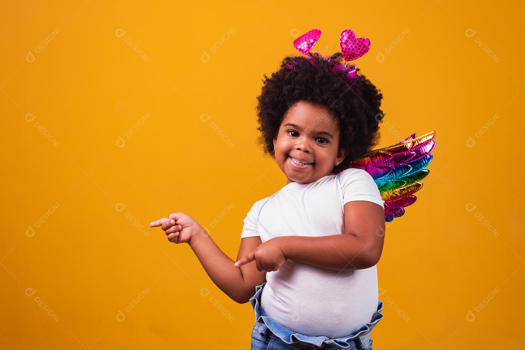 adorável garota afro vestida com roupa colorida em backgrou amarelo