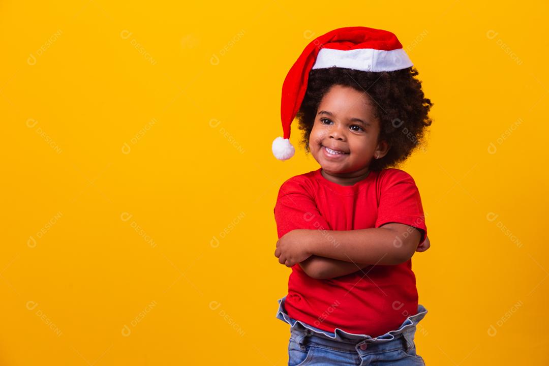 Menina afro de camiseta vermelha e chapéu de Papai Noel vestido para cristo