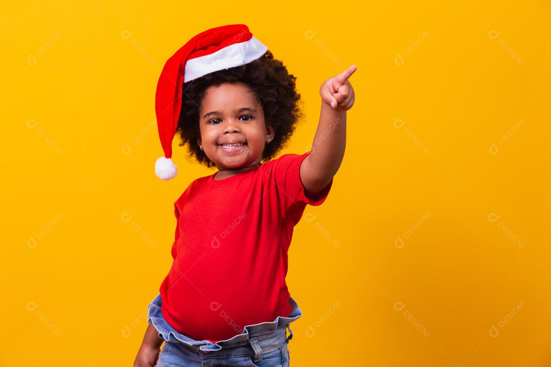 Menina afro de camiseta vermelha e chapéu de Papai Noel vestido para cristo