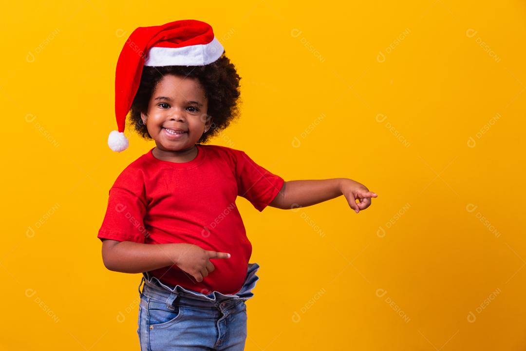 Menina afro de camiseta vermelha e chapéu de Papai Noel vestido para cristo