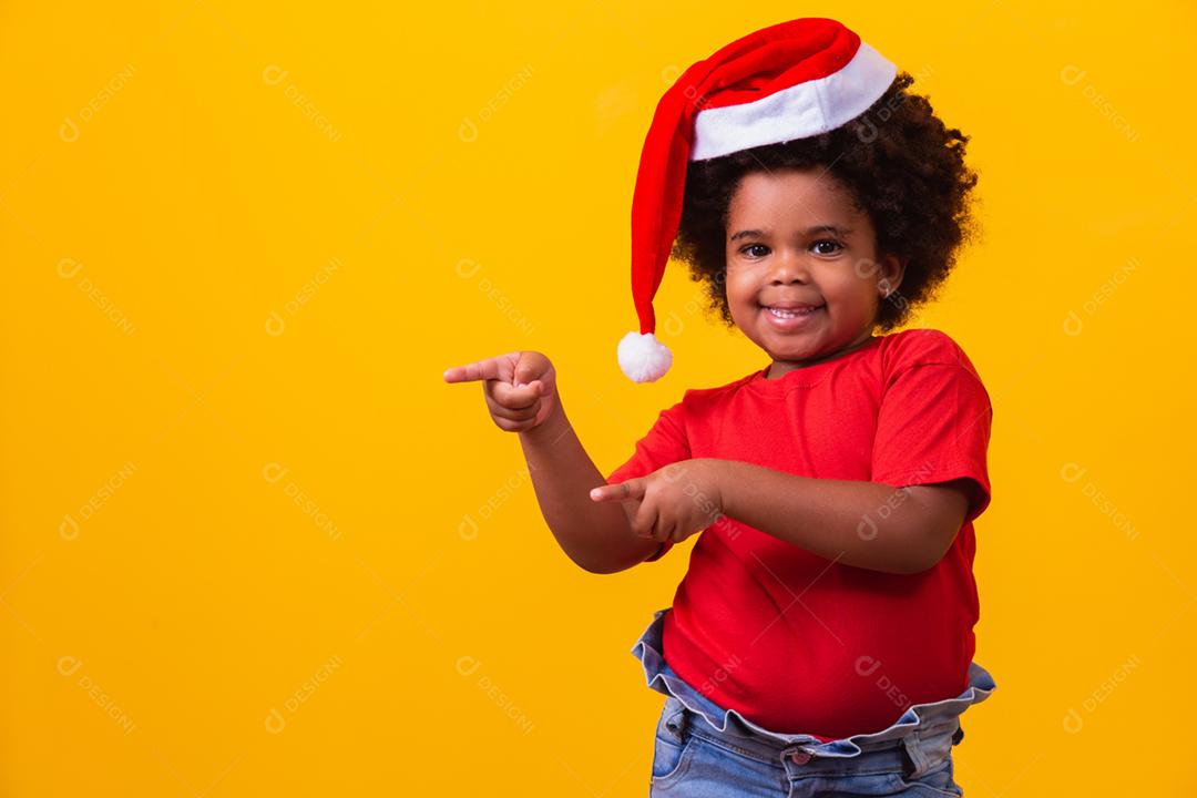 Menina afro de camiseta vermelha e chapéu de Papai Noel vestido para cristo