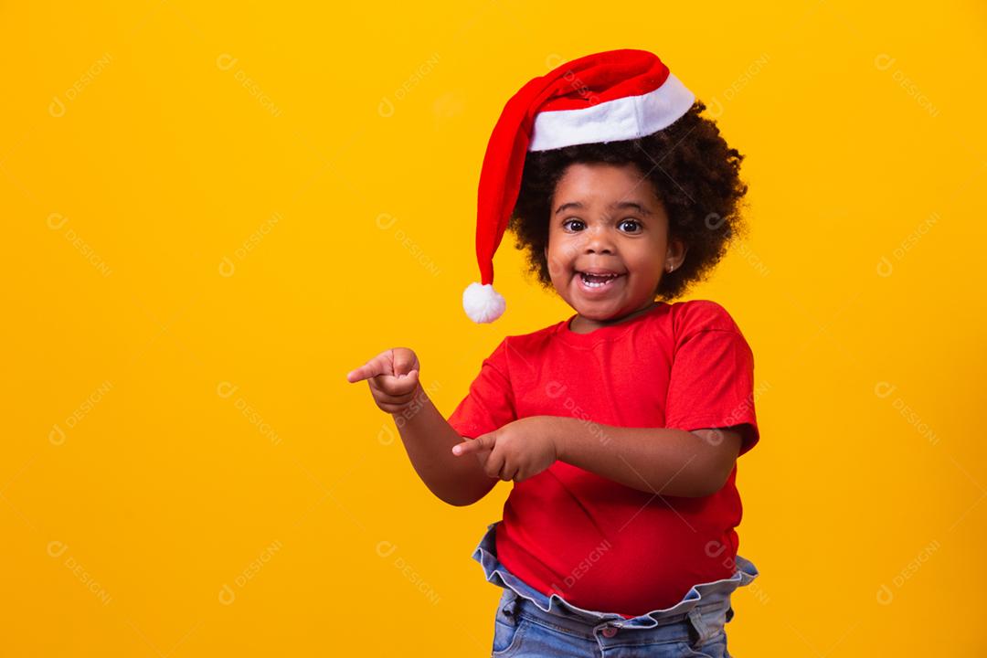 Menina afro de camiseta vermelha e chapéu de Papai Noel vestido para cristo
