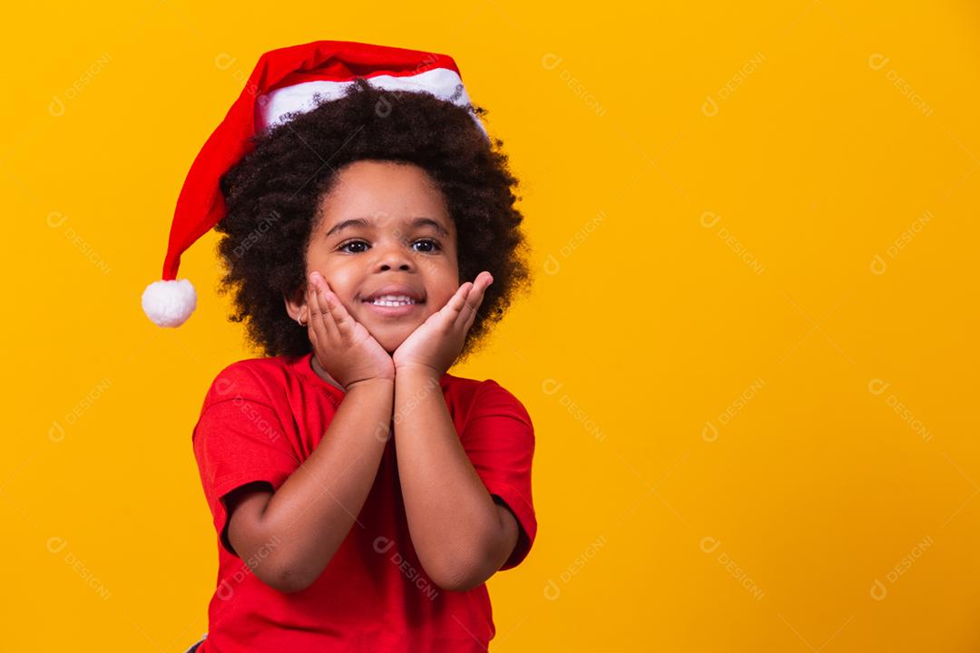 Adorável menina afro de camiseta vermelha e chapéu de Papai Noel vestido f