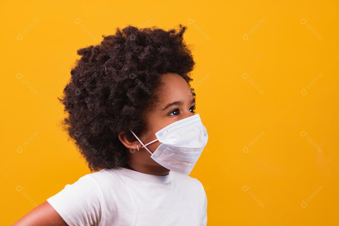Menina afro pequena com máscara protetora cirúrgica contra covi