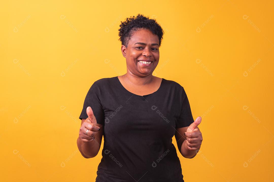 Mulher madura afro com polegar para cima dando polegares para cima.