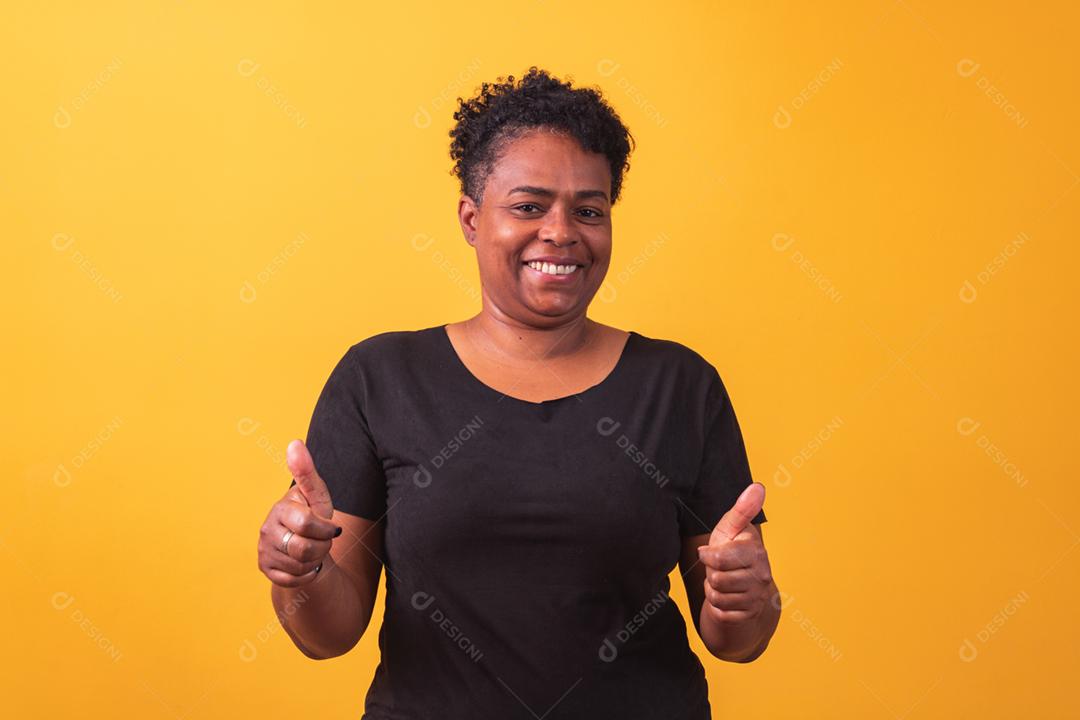 Mulher madura afro com polegar para cima dando polegares para cima.