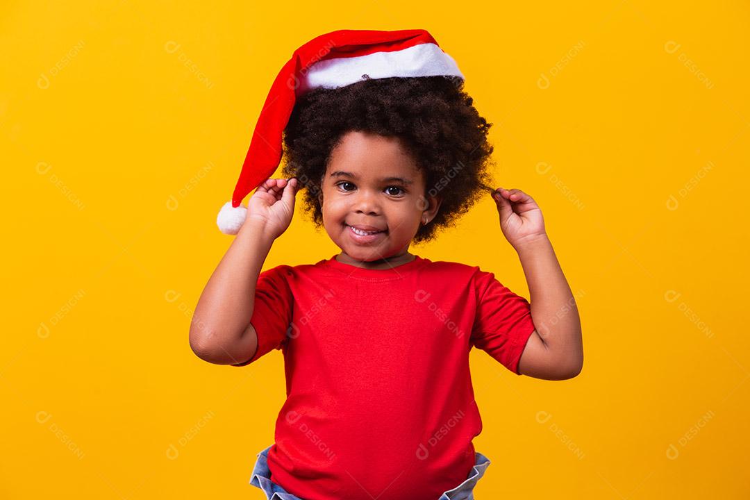 Menina afro com chapéu de Papai Noel.