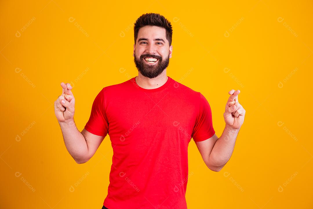 jovem rapaz bonito com dedos cruzados, desejando sorte