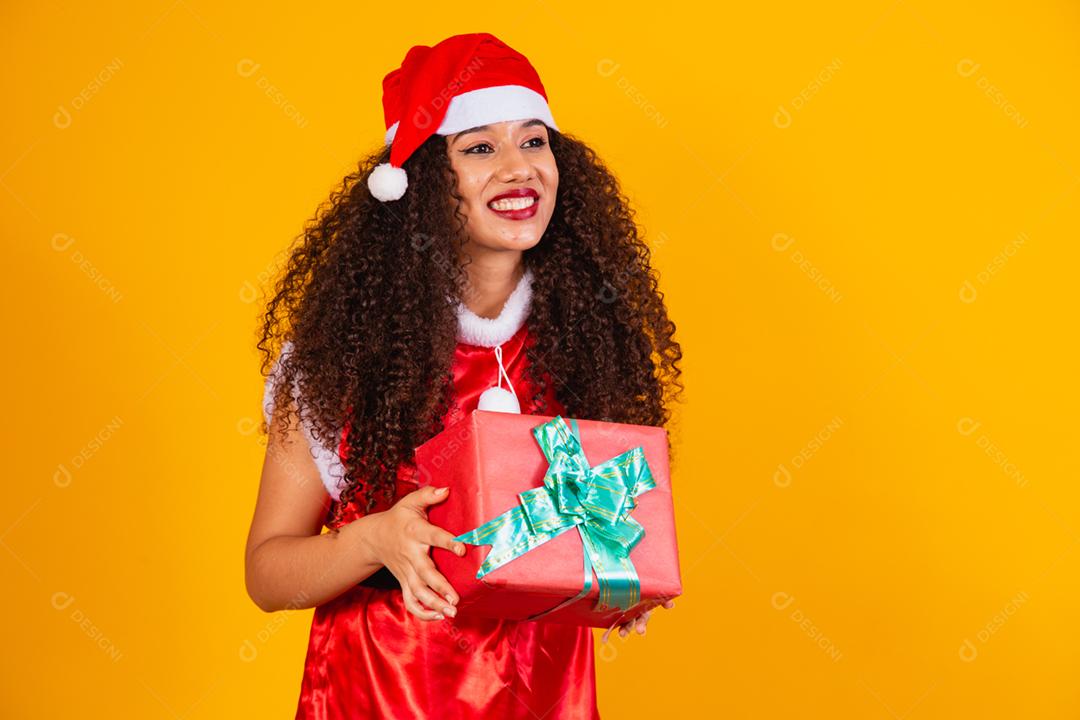 jovem noelete vestida para o natal apontando para o espaço livre