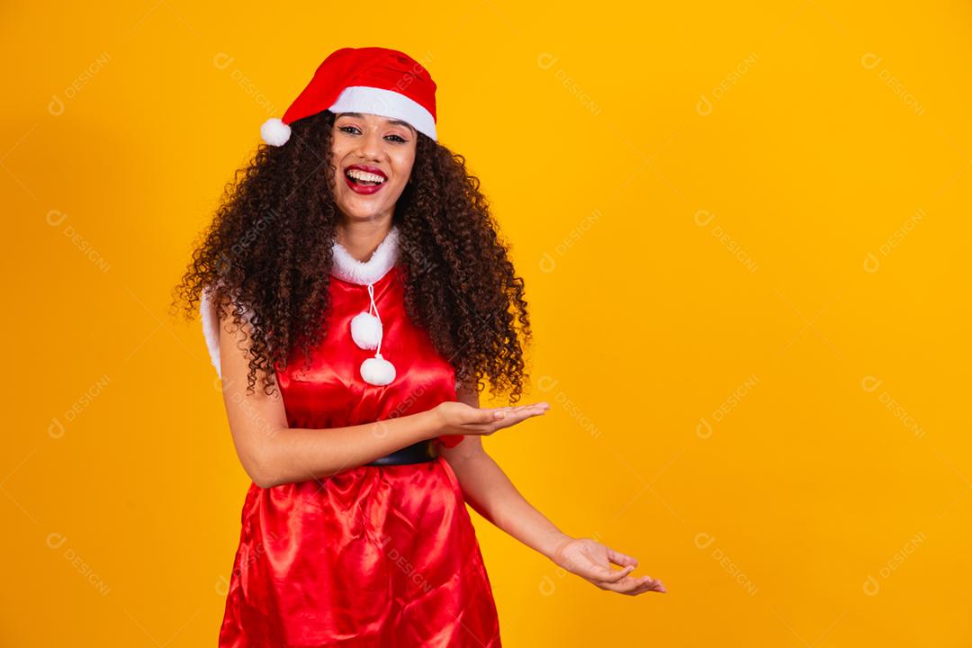 jovem noelete vestida para o natal segurando um presente em amarelo
