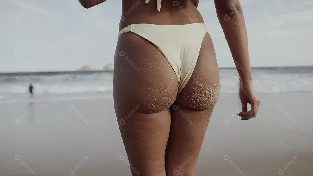 Pernas de mulher na praia. Garota andando na areia à beira-mar. Viagem de praia. Conceitos de férias de verão.