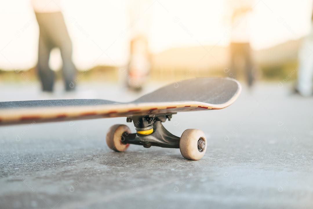 skate em primeiro plano com crianças skatistas falando ao fundo - amigos adolescentes se divertindo patinando