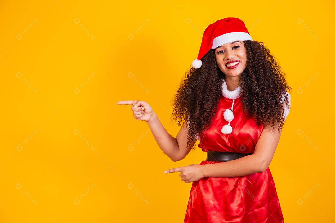 jovem noelete vestida para o natal apontando para o lado