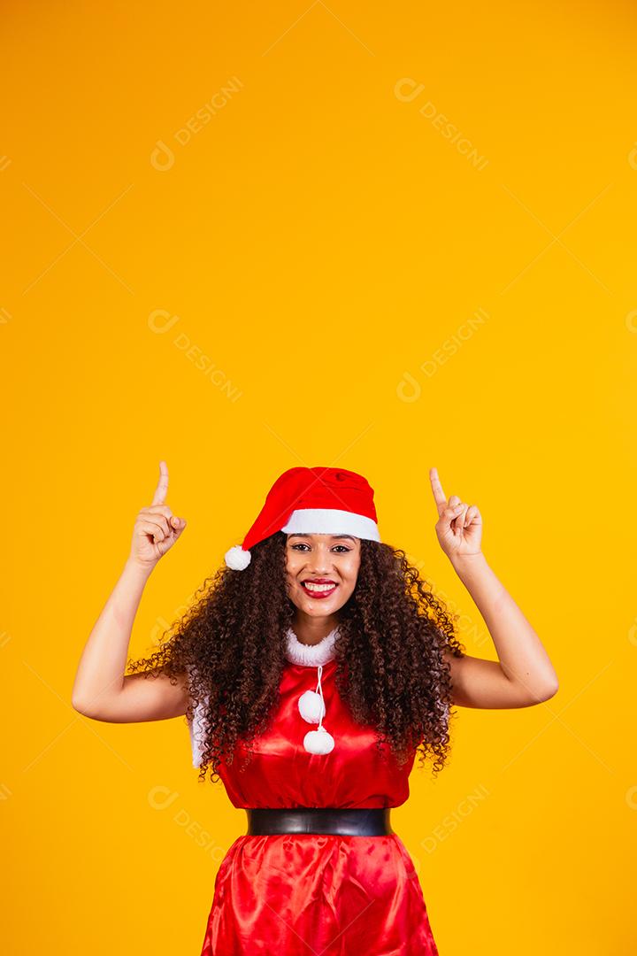 jovem noelete vestida para o natal apontando