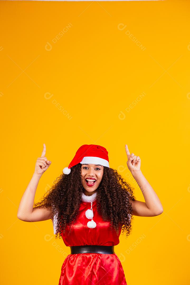 jovem noelete vestida para o natal apontando
