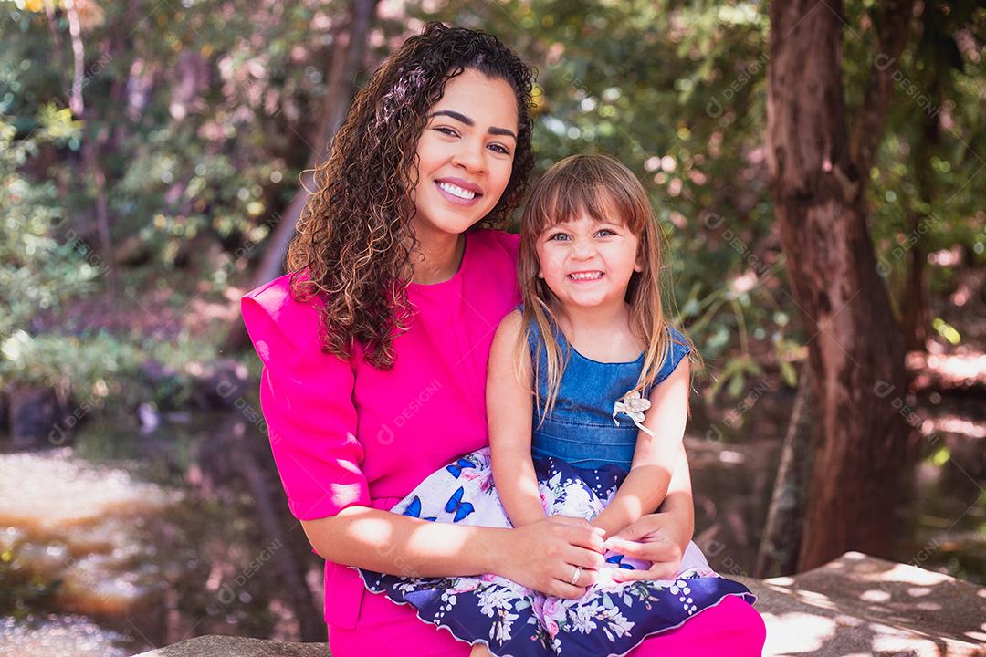 mãe com a filha no colo no parque. Linda jovem mãe com a filha no parque. Mãe solitária. Dia das Mães