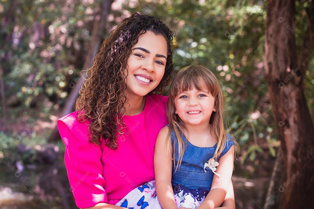 mãe com a filha no colo no parque. Linda jovem mãe com a filha no parque. Mãe solitária. Dia das Mães