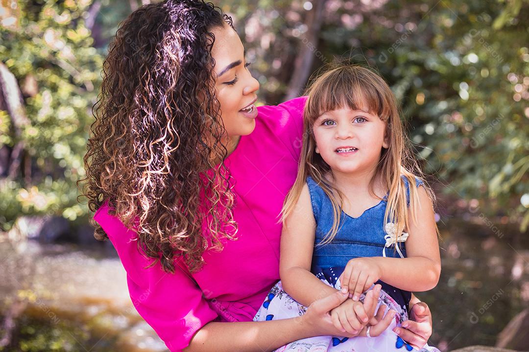 mãe com a filha no colo no parque. Linda jovem mãe com a filha no parque. Mãe solitária. Dia das Mães