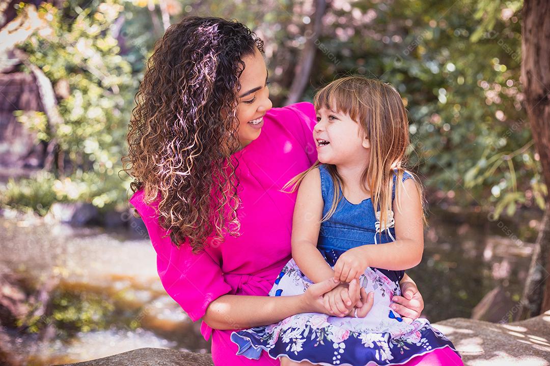 mãe com a filha no colo no parque. Linda jovem mãe com a filha no parque. Mãe solitária. Dia das Mães