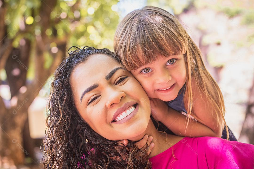 adorável jovem mãe com sua filha trocando carinho. Mãe e filha no parque. Feliz Dia das Mães
