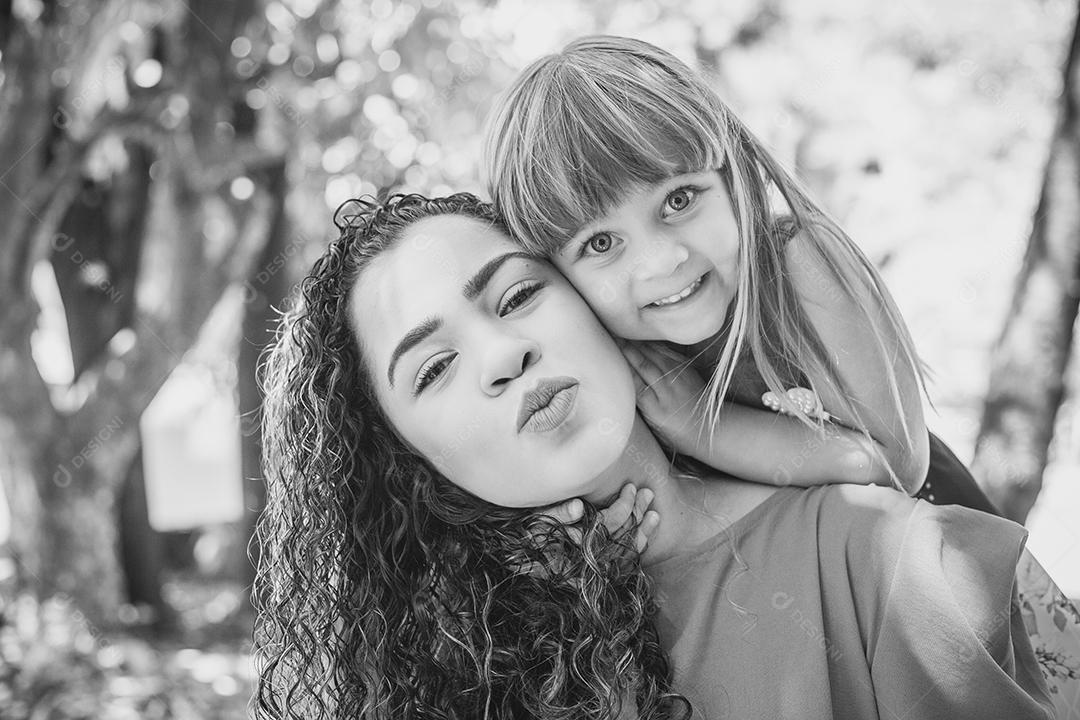 adorável jovem mãe com sua filha trocando carinho. Mãe e filha no parque. Feliz Dia das Mães