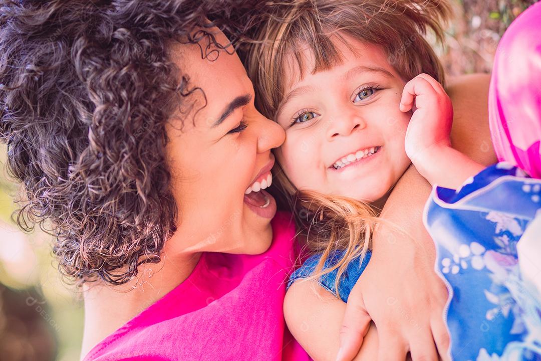 adorável jovem mãe com sua filha trocando carinho. mãe e filha no parque. feliz Dia das Mães