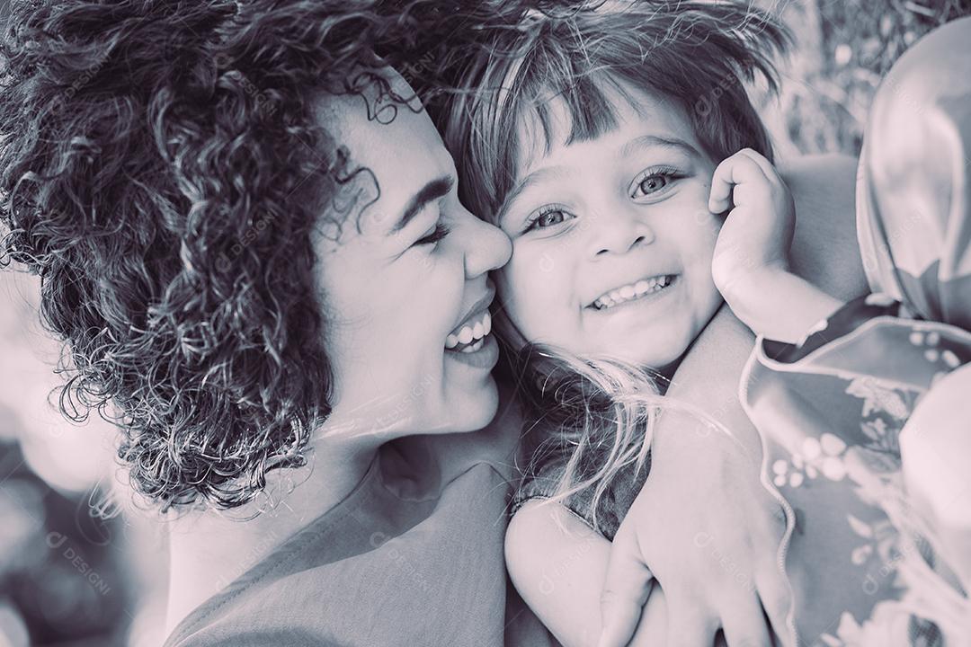 adorável jovem mãe com sua filha trocando carinho. Mãe e filha no parque. Feliz Dia das Mães