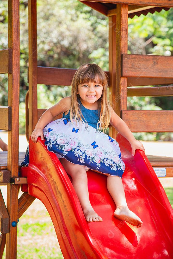 linda menina caucasiana brincando no playground.