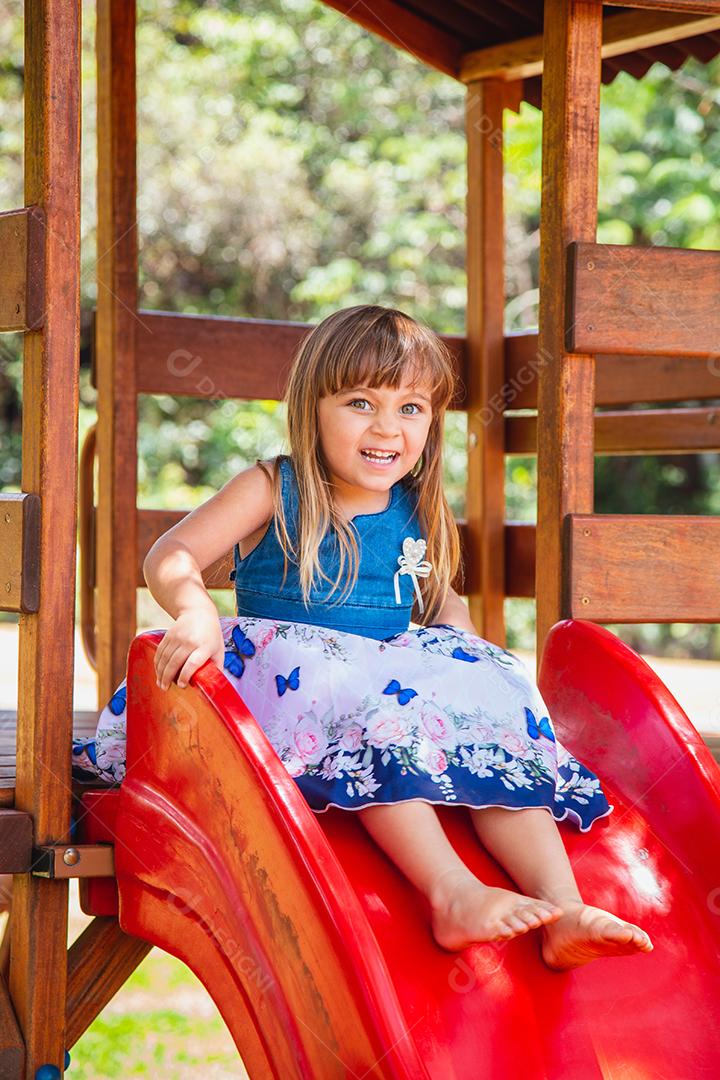 linda menina caucasiana brincando no playground.