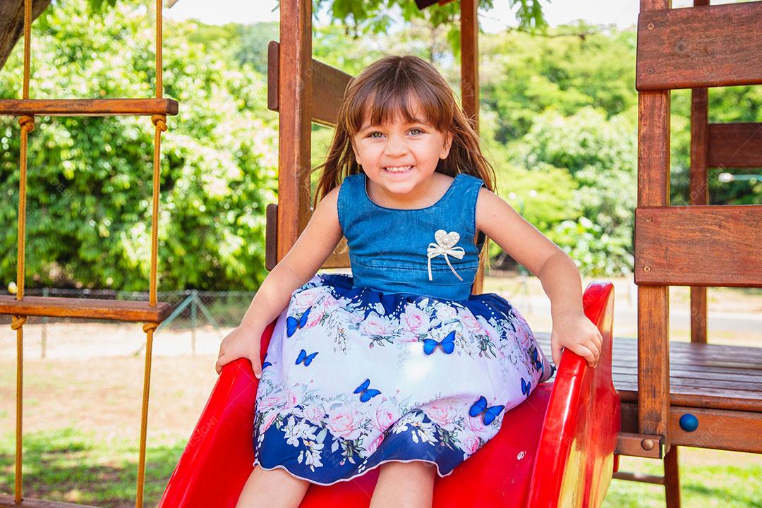 linda menina caucasiana brincando no playground.