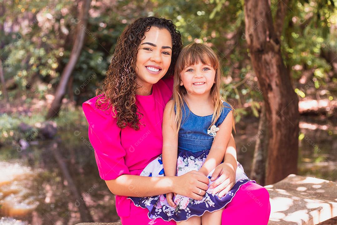 mãe com a filha no colo no parque. Linda jovem mãe com a filha no parque. Mãe solitária. Dia das Mães